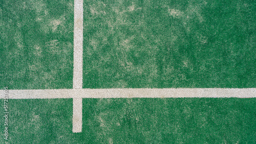 Top view of line on floor and part of green synthetic grass paddle tennis court
