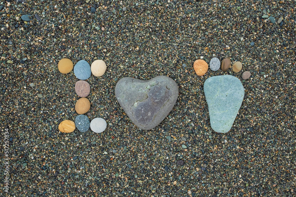 Steps of man, woman and kid made from stones on sandy beach. Steps of man, woman and kid made from stones on sandy beach.