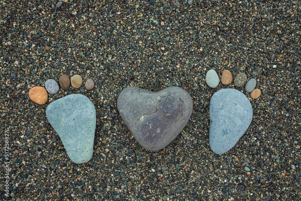 Steps of man, woman and heart made from stones on sandy beach. Steps of man, woman and heart made from stones on sandy beach.