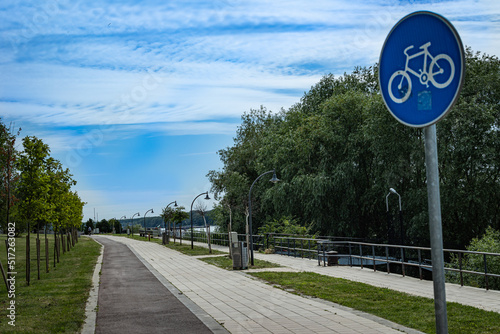 Bike lane marked with oval, blue street sign next to footpath on the Danube river walking trail in the city of Ruse, Bulgaria