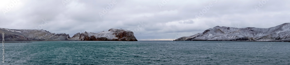 Panorama of snow dusted mountains around the pass at the entrance to the crater bay in Deception Island, Antarctica