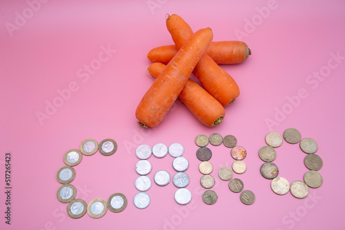 Some carrots with the word dear written with coins photo