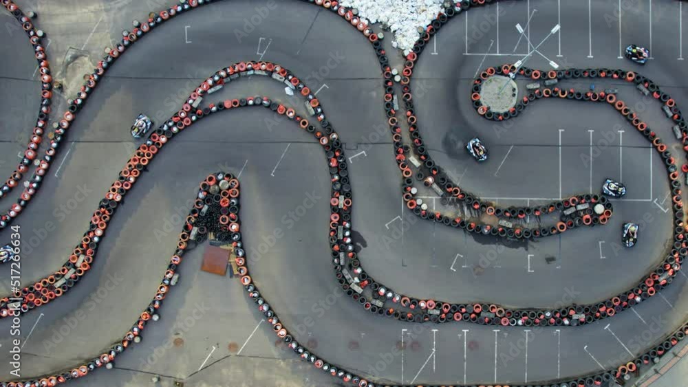 Aerial top view of the go-kart track from the drone. Kart racers drive on the open track. Kart racing open wheel motorsport competition. High quality 4k footage