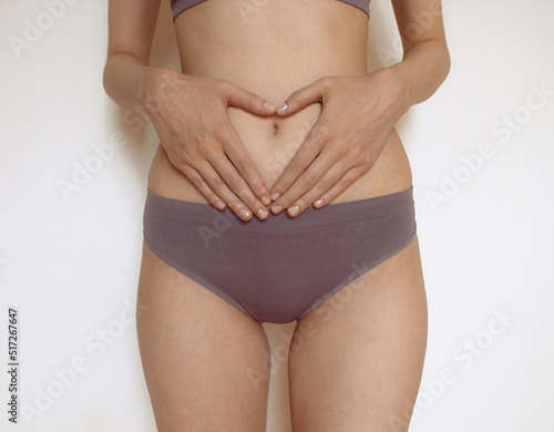 women Health Gynecology, menstruation, the concept of genital health woman hands on belly woman holds fingers in the form of a figure a heart before a stomach