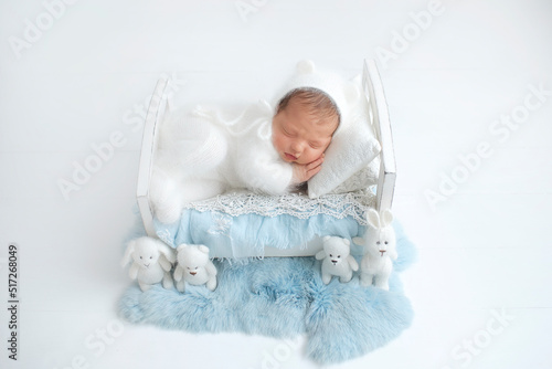 Newborn baby in a hat. A sweet newborn baby is sleeping. The first photo session of the baby.