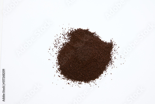 overhead shot of pile of coffee grounds isolated on white background  photo