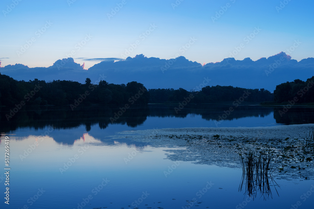 Blue cloudy riverscape in the evening