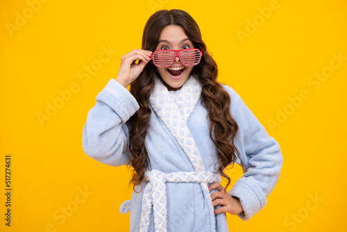 Portrait of crazy teenage girl in funny glasses and pajama or home bathrobe feeling fun. Kids pajama party. Amazed teen girl. Excited expression, cheerful and glad.
