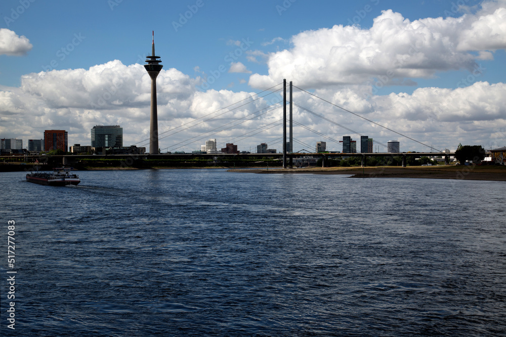 TV tower in Düsseldorf near the river against a blue sky with white clouds
