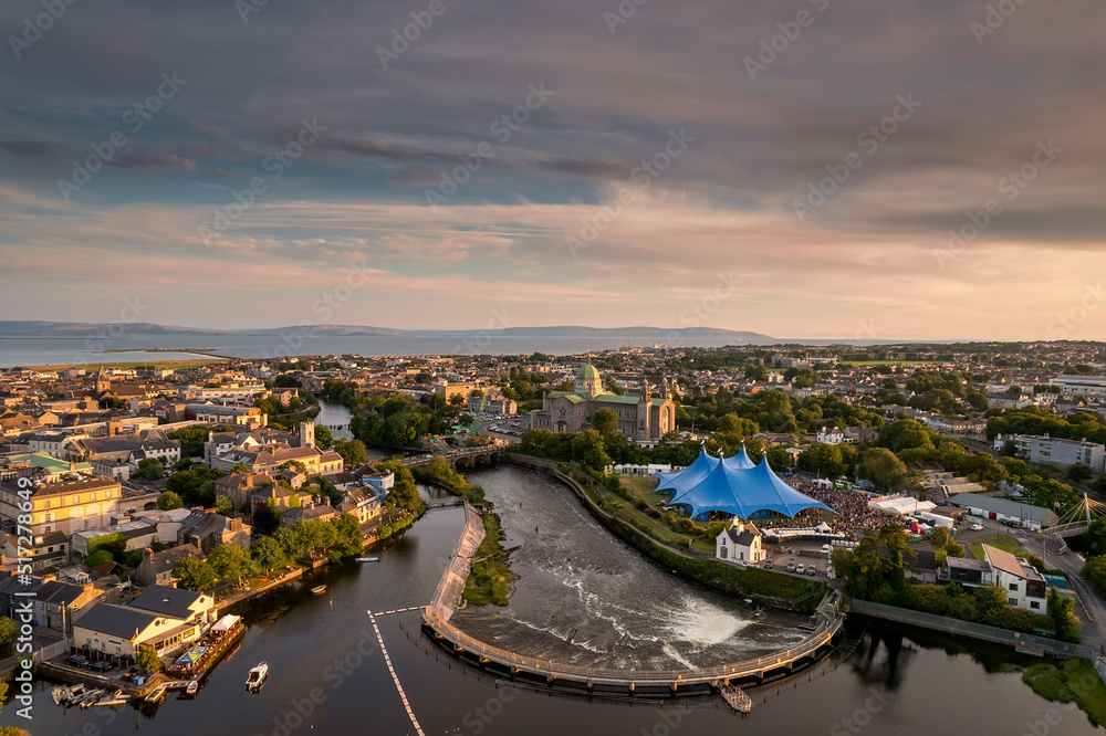 Aerial view on river Corrib and blue concert performance tent. Dusk sunset time. Popular town event. Tourism and travel and entertainment industry. Galway, Ireland.