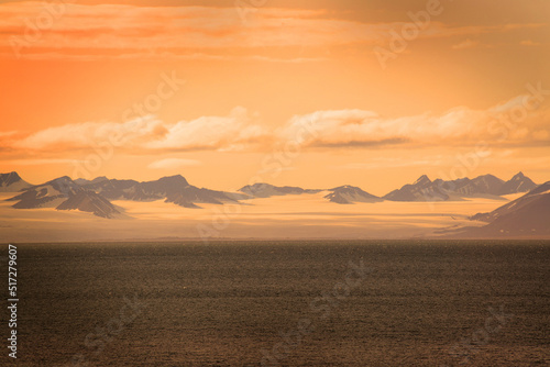 Colourful skies on the Norwegian archipelago of Svalbard. In summer  these kind of  sunsets  can last all night. A glacier is also visible.