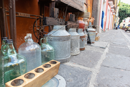 old vintage glass and metal bottles and jars at sale in a street market in Puebla city, Mexico