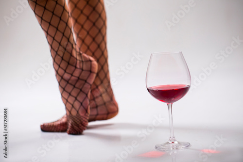 wine in a glass. Sexy woman legs. Red wine. Alcohol. Drink. Sensual