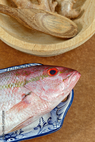 Raw red  snapper fish in decorated platter, ready to prepare photo