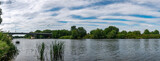 krajobraz rzeki Odry w zachodniej Polsce w jasnych zielono niebieskich barwach i lekko pochmurnej pogodzie