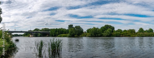 Fototapeta Naklejka Na Ścianę i Meble -  krajobraz rzeki Odry w zachodniej Polsce w jasnych zielono niebieskich barwach i lekko pochmurnej pogodzie