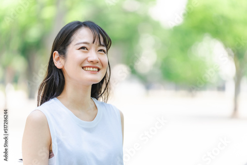 緑の中で笑う若い日本人女性（環境・美白・SDGs/笑顔） 