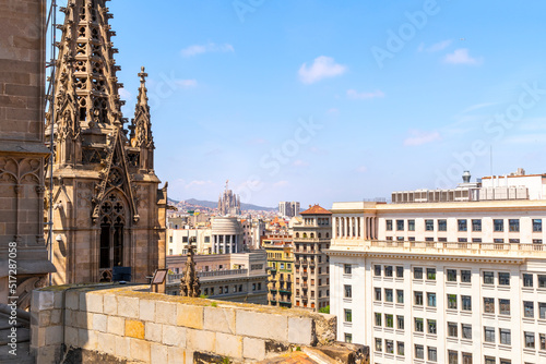 View from the rooftop terrace of the Gothic Barcelona Cathedral of the cityscape and skyline including Gaudi's La Sagrada Familia church.