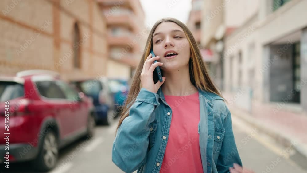 Adorable girl talking on the smartphone walking at street Adorable girl talking on the smartphone walking at street
