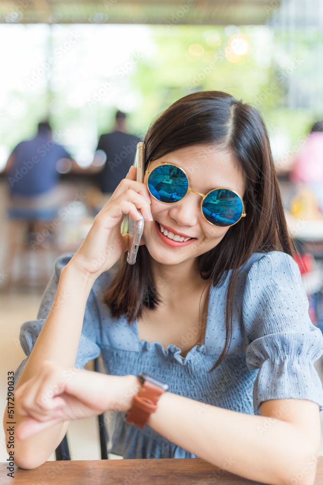 Business asian women sitting in cafe use smartphone