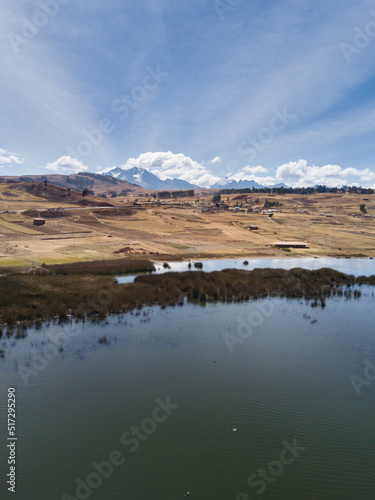 Aerial view of Huaypo Lake. Water source in the high Andes of Cusco Peru. Sunny day in Andean rural landscape.