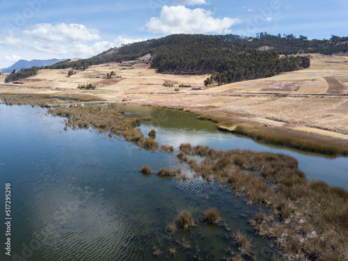 Aerial view of Huaypo Lake. Water source in the high Andes of Cusco Peru. Sunny day in Andean rural landscape.