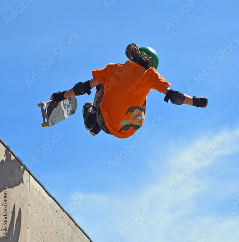 Skateboarder performing grab stunt on Vert Ramp.