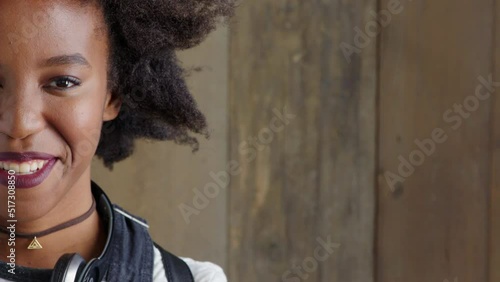 Closeup of a laughing woman showing a cheerful facial expression against a wooden background with copy space. Half portrait, headshot and face of smiling, fun and young, edgy woman giggling at a joke