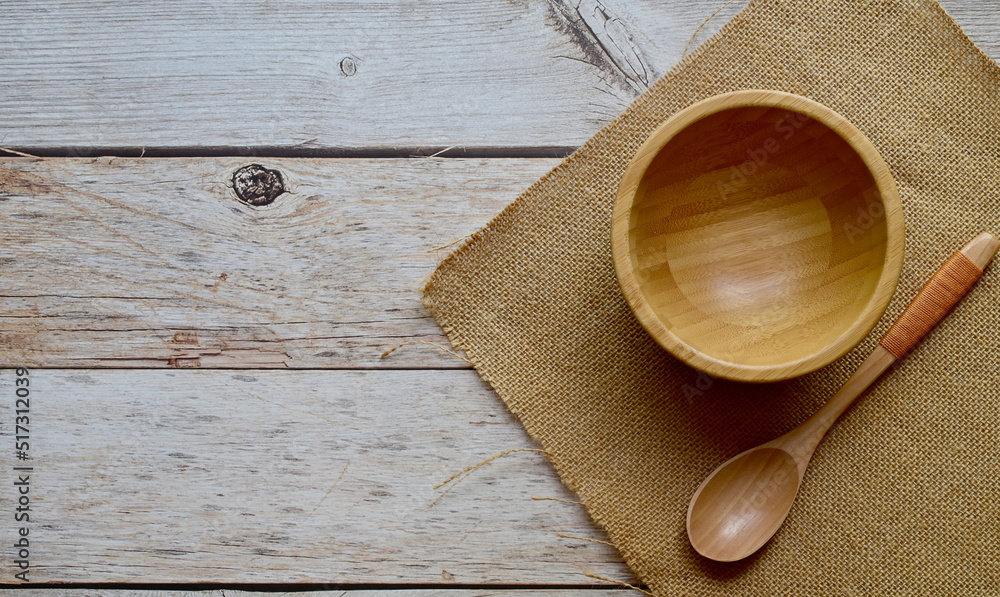 Top Views of Empty wooden cup and wooden spoon and sackcloth on sacks on a wooden background, The concept of cooking utensils made of wood. Top Views of Empty wooden cup and wooden spoon and sackcloth on sacks on a wooden background, The concept of cooking utensils made of wood.