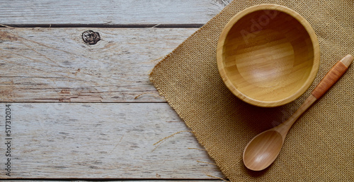 Top Views of Empty wooden cup and wooden spoon and sackcloth on sacks on a wooden background, The concept of cooking utensils made of wood.
