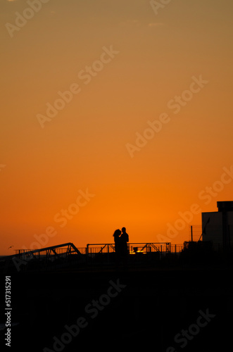 lovingly embracing lovers in a harbour at sunset