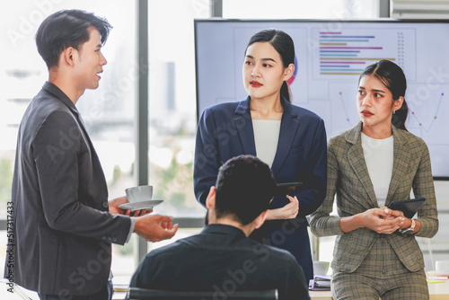 Millennial Indian Asian professional successful male female businessman businesswoman group in formal suit sitting together discussing brainstorming sharing business solution ideas in meeting room. © Bangkok Click Studio