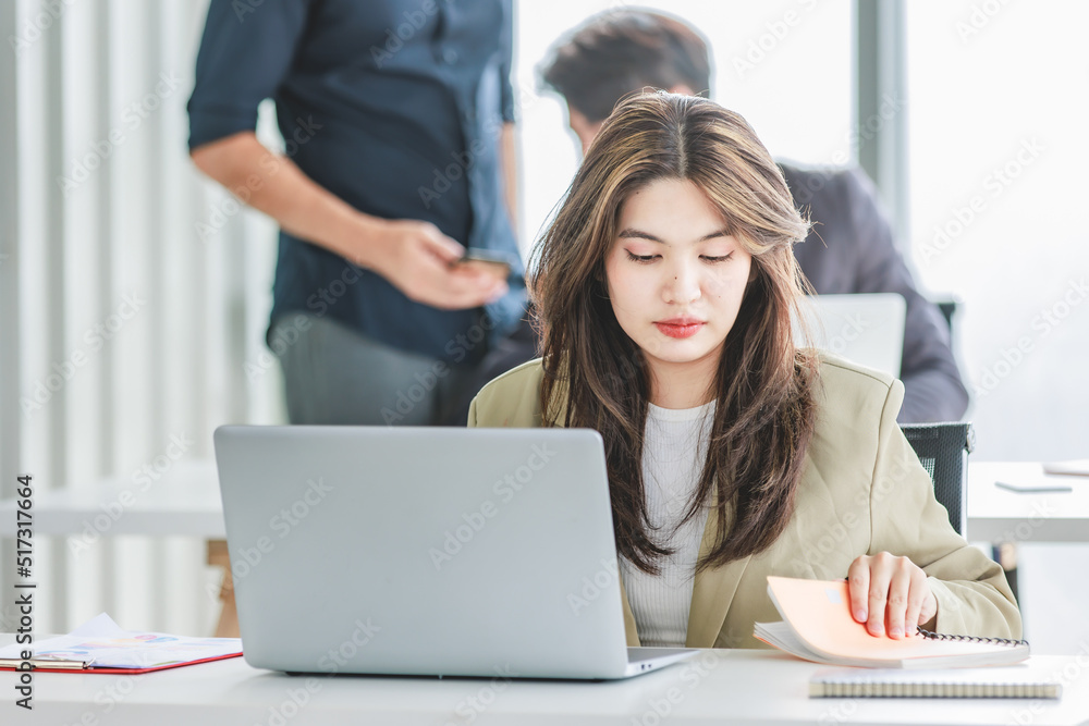 Closeup shot of millennial Asian young stressed depressed sleepy female businesswoman employee sitting holding hand on messy hair working on workstation desk via laptop notebook computer in office Closeup shot of millennial Asian young stressed depressed sleepy female businesswoman employee sitting holding hand on messy hair working on workstation desk via laptop notebook computer in office