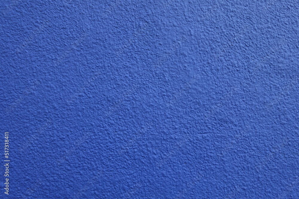 Surface of wall with coarse vibrant blue roughcast finish Surface of wall with coarse vibrant blue roughcast finish