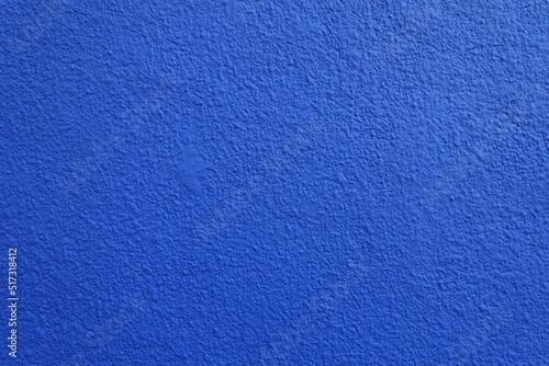 Texture of wall with coarse vibrant blue roughcast finish photo