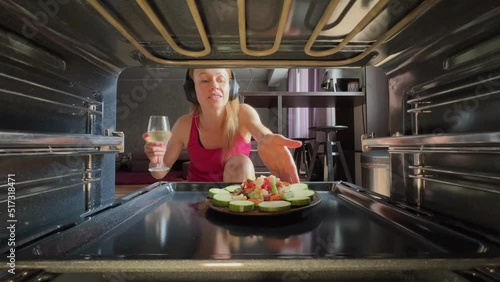 Female cook salat in oven at the kitchen