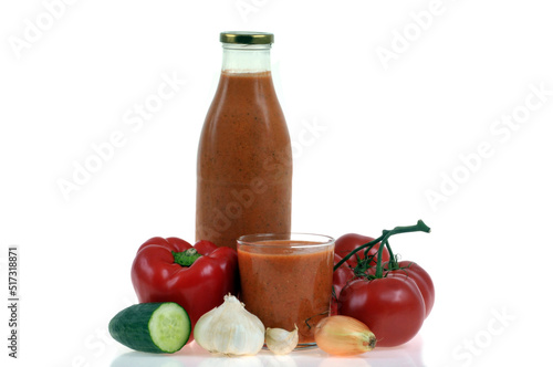  Bouteille et verre de gaspacho maison avec ses ingrédients sur fond blanc