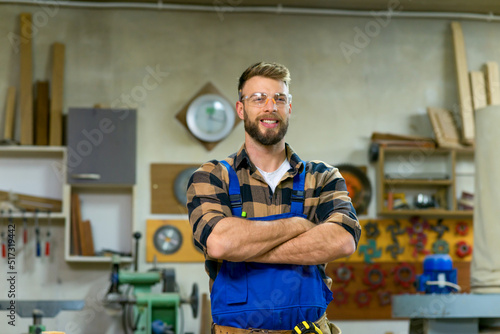 Portrait of smiley handsome carpenter at his workplace