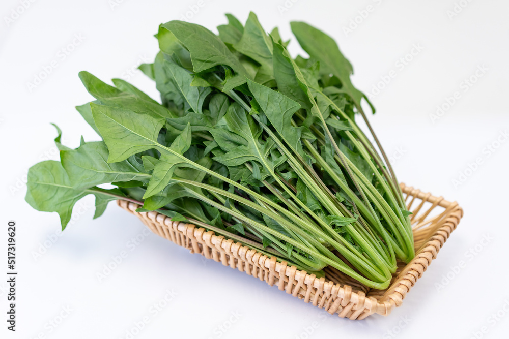 The fresh vegetables in the basket are placed on the white table The fresh vegetables in the basket are placed on the white table