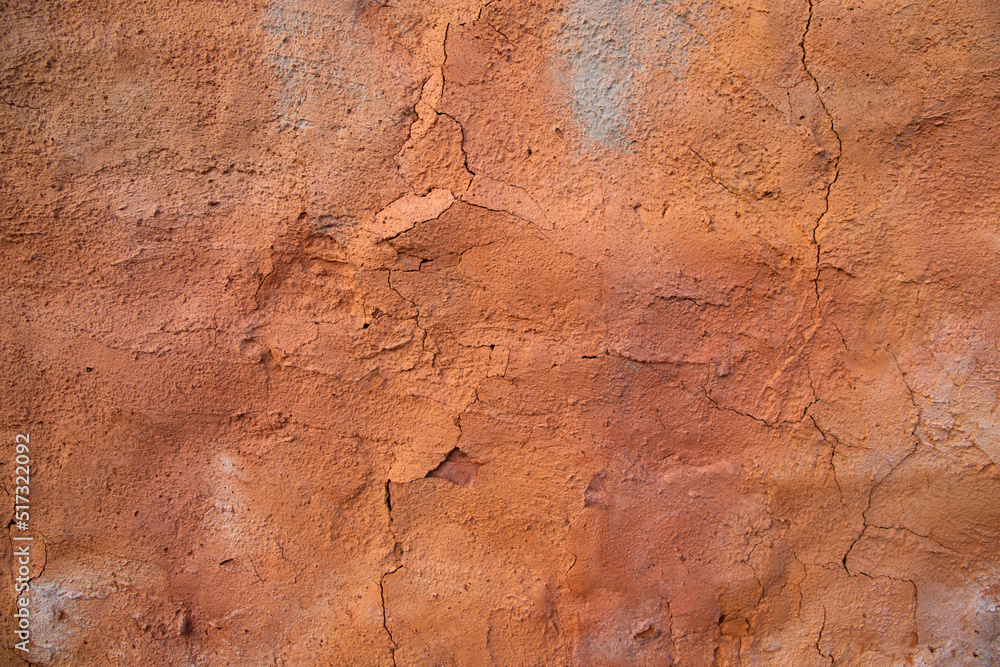 The texture of a red concrete wall with cracks and scratches can be used as a background The texture of a red concrete wall with cracks and scratches can be used as a background
