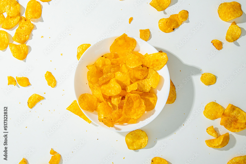Chips in a white plate on a white background. Top view, flat lay Chips in a white plate on a white background. Top view, flat lay