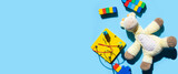 Children's educational toys are scattered on a blue background. Top view, flat lay. Banner