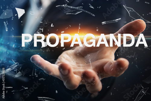 Hand of a businessman presenting the word propaganda. Propaganda concept in business, politics or news