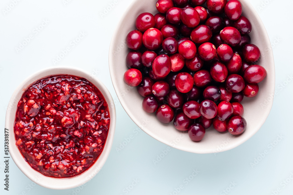 Cranberries in white bowl on pastel background. Cranberries in white bowl on pastel background.