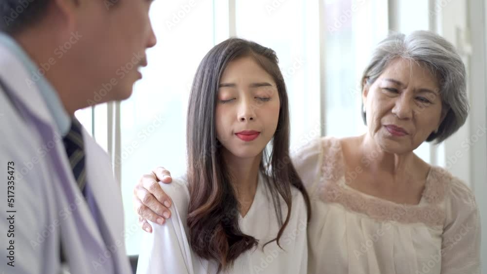 Asian young woman and her mother taking to doctor.