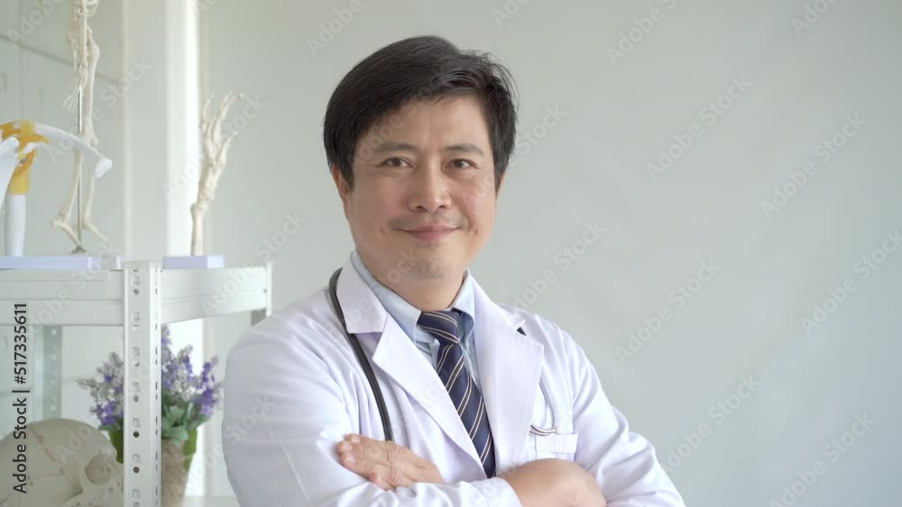 Happy Asian male doctor making arms crossed and smiling to camera. 