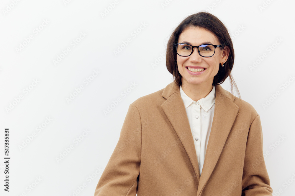 portrait of a cute, beautiful, attractive woman in glasses on a light background in a stylish brown coat. Horizontal photo on a light background with empty space portrait of a cute, beautiful, attractive woman in glasses on a light background in a stylish brown coat. Horizontal photo on a light background with empty space