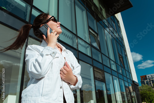 Portrait of smiling caucasian woman with white teeth talking on phone, having pleasant conversation, hold mobile device. Perfect healthy smile with veneer. Dental care. 