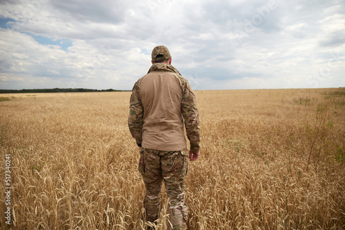Ukrainian military man in wheat field. Ukrainian wheat fields and war upcoming food crisis. Armed Forces of Ukraine © leravalera89