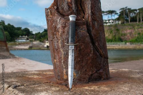 Photography Commando dagger lens against a rusty post on the waterfront